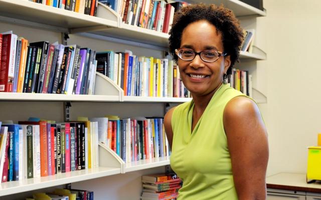 Carolyn Rouse in front of full bookshelves