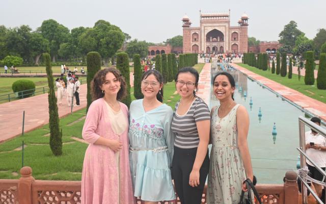 Four PSIP Bengalaru students pose in front of a long reflecting pool beautiful gardens and a mosque near the Taj Mahal