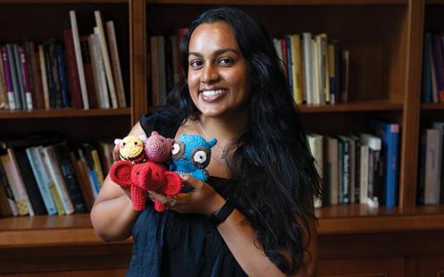 smiling young woman holding adorable crocheted animals