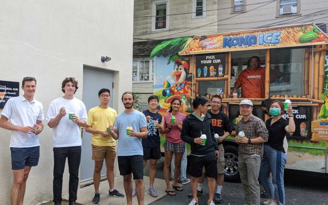 Students lined up outside a Kona Ice Truck with shaved ice cups in their hands.