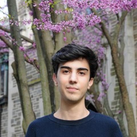 Amir Touil standing in front of flowering tree