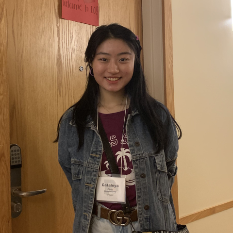 Student smiling in front of classroom door