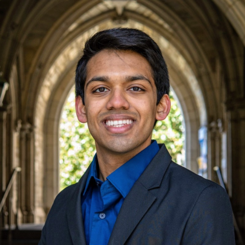 Student smiling in front of archway