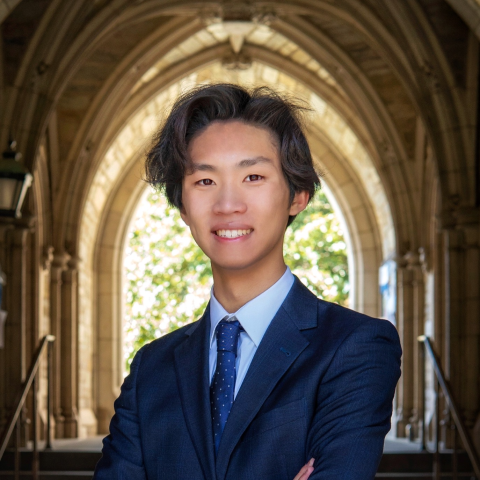 Student smiling in front of archway